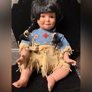 This is a vintage Danbury Mint Native American porcelain doll.Song of the Sioux